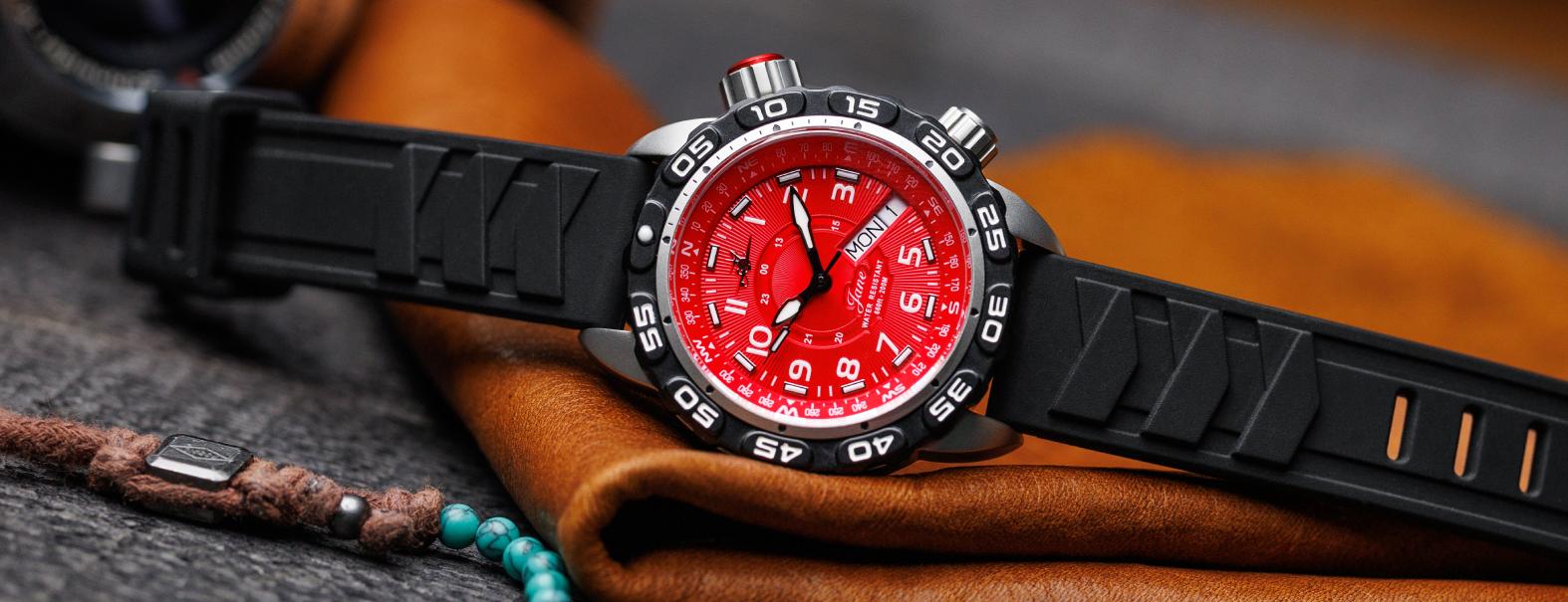 Abingdon Co. A image displaying Jane Mission analog quartz movement watch with black silicone strap front view. black watch head that has a black silicone band and a red dial front image of watch on display