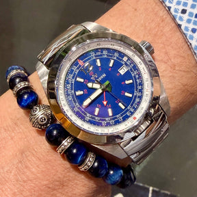 Abingdon Co. image displaying Bonneville Blue silver steel analog watch with steel strap on a wrist with a blue and silver bracelet. Blue dial with Red GMT and E6B flight computer. Sapphire crystal, Swiss movement. Limited Edition 18 pieces only