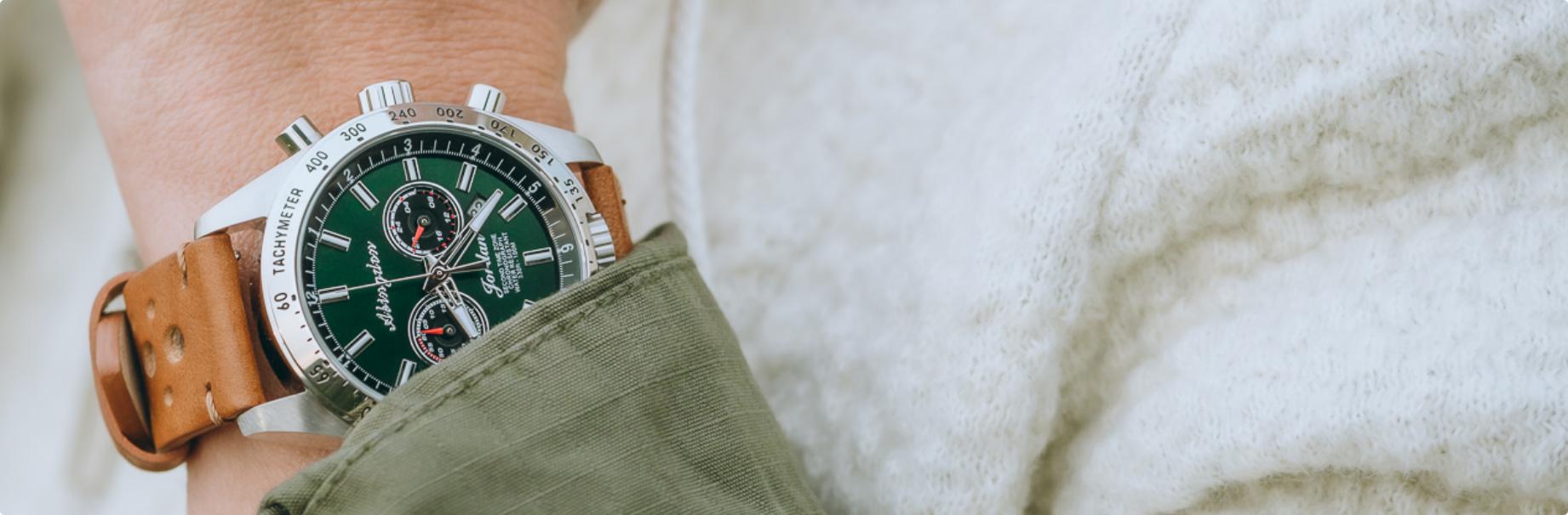 green dial Abingdon watch with a brown leather strap on a woman's wrist with a jacket