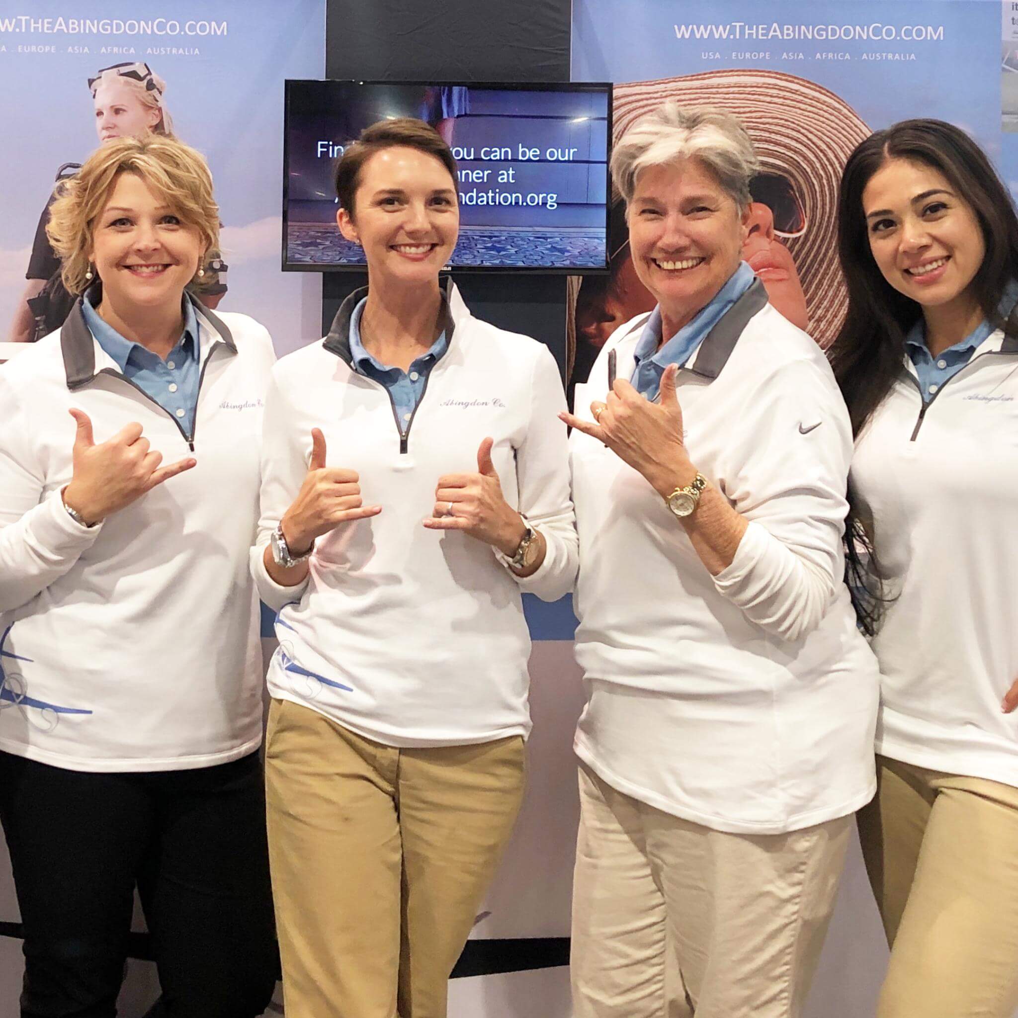 Abingdon Co. Image displays  women, employees of Abingdon Co. are standing giving a thumbs up all dressed in company uniforms