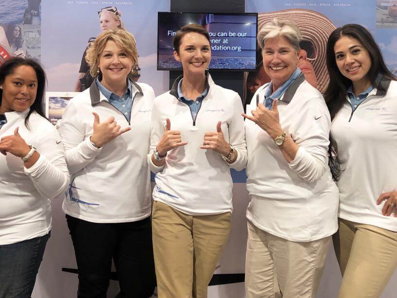 Abingdon Co. Image displays  women, employees of Abingdon Co. are standing giving a thumbs up all dressed in company uniforms