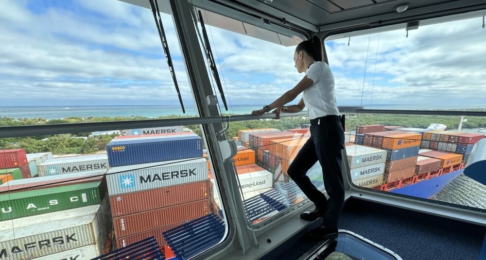 Abingdon Co. image displays Captain Kate McCue looks out from the bridge at a cargo ship passing by loaded with containers from all over the world. 