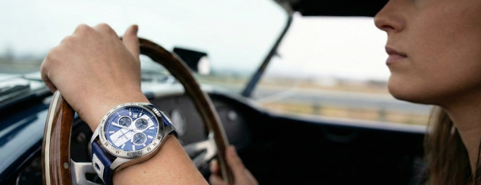 Woman driving a car with an Abingdon Co Jordan watch on their wrist with a blue face.
