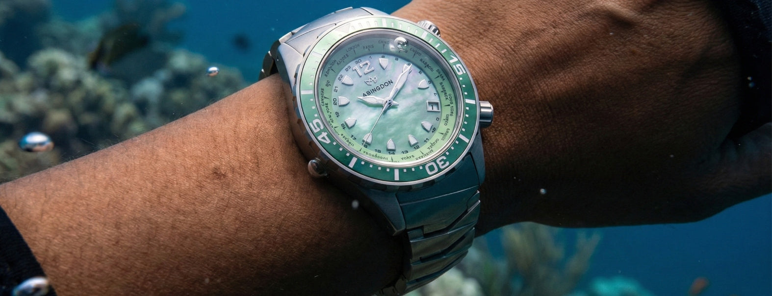 Abingdon Co Marina wristwatch with a green face on a wrist over an underwater coral reef background