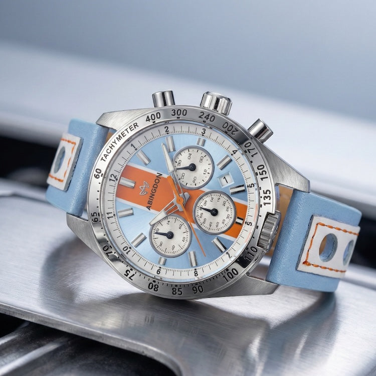 Abingdon Co Jordan watch with a blue strap and orange accents on a metallic surface