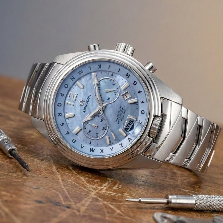Abingdon Co Katherine silver watch with a blue MOP face on a wooden surface with watch tools.