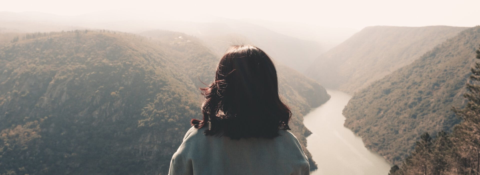 A PERSON STANDING AT A CORNER TAKING IN the forest views